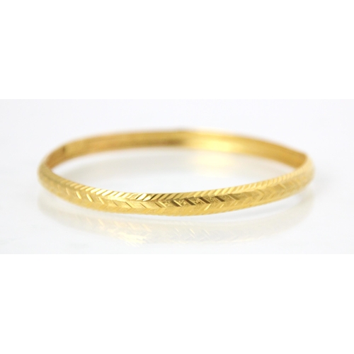 173 - A yellow metal bangle, the grooved and engraved detailed bangle with ‘7AS22’ applied pad, 10gms