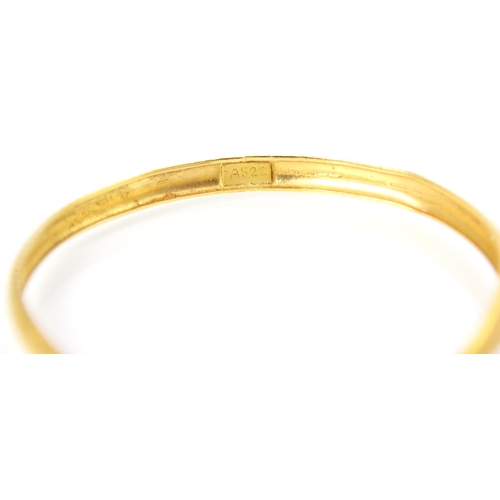 173 - A yellow metal bangle, the grooved and engraved detailed bangle with ‘7AS22’ applied pad, 10gms