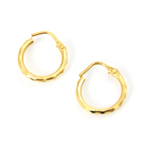 176 - A pair of yellow metal hoop earrings, the faceted hoops with post fittings, stamped ‘916’ with a fur... 