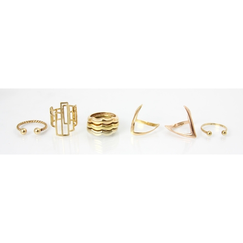 177 - A selection of six yellow metal and gold coloured rings, including a plain polished stylised wishbon... 