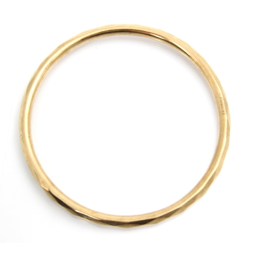 178 - A 9ct yellow gold bangle, the hollow bangle with faceted detail to exterior, stamped Chester 1928, 9... 