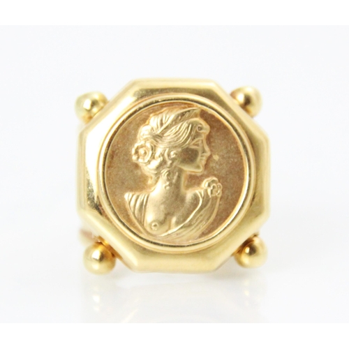 201 - A yellow metal dress ring, the octagonal shaped head of the ring with engraved detail depicting head... 