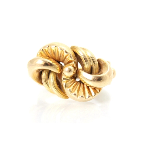 202 - A yellow metal dress ring, the stylised lobed head with textured and plain polished detail, leading ... 