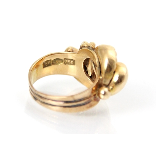 202 - A yellow metal dress ring, the stylised lobed head with textured and plain polished detail, leading ... 