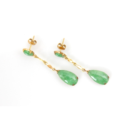 213 - A pair of untested jade earrings, the cabochon cut green stone stud within yellow metal mount, with ... 