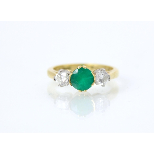 222 - An 18ct yellow gold untested emerald and diamond three stone ring, the central round cut green stone... 