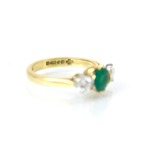 222 - An 18ct yellow gold untested emerald and diamond three stone ring, the central round cut green stone... 