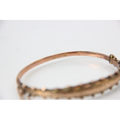 226 - An early 20th century 9ct rose gold bangle, the raised engraved front with spherical and beaded deta... 