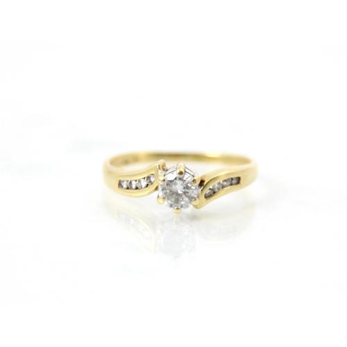 249 - A diamond solitaire ring, the central round cut diamond within yellow gold mount with diamond set sh... 