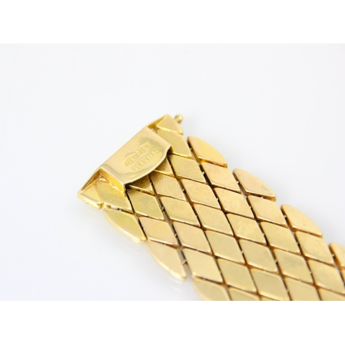 251 - A yellow metal bracelet, the flat lozenge shaped links with box and tongue fastening, stamped ‘750’ ... 