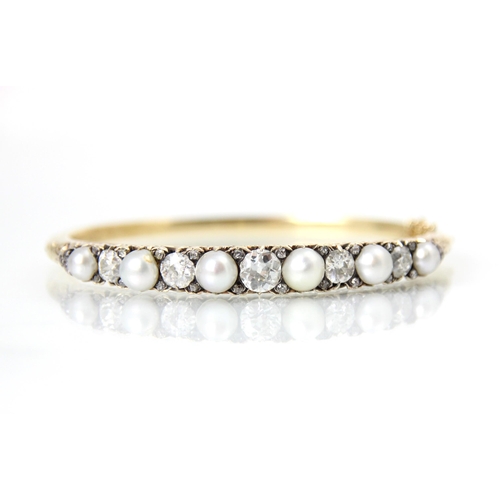 286 - An early 20th century diamond and pearl set bangle, the five old cut diamonds interspersed with rose... 