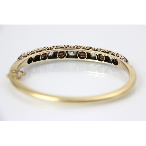 286 - An early 20th century diamond and pearl set bangle, the five old cut diamonds interspersed with rose... 