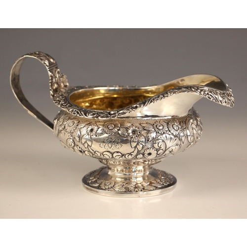 69 - A George IV silver milk jug, possibly Hyam Hyams, London 1824, the cast floral rim above embossed bo... 