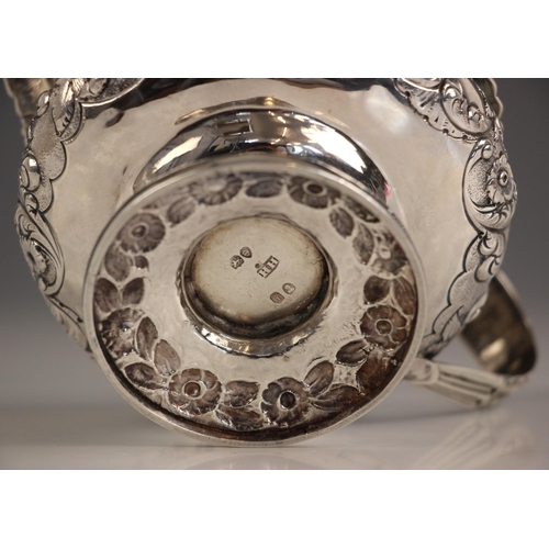 69 - A George IV silver milk jug, possibly Hyam Hyams, London 1824, the cast floral rim above embossed bo... 