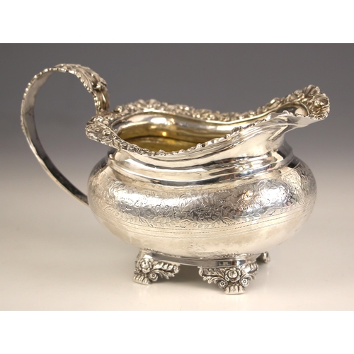 70 - A George III silver milk jug, possibly CH, London possibly 1820, the cast floral rim above scrolling... 