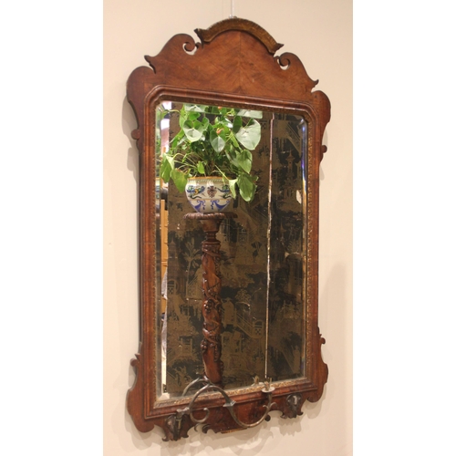 869 - A George III mahogany fretwork girandole wall mirror, the arched and scrolled frame enclosing the re... 