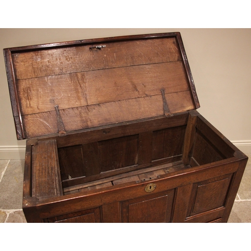 917 - An early 18th century oak mule chest, the three plank top opening to a fitted candle box and two sma... 