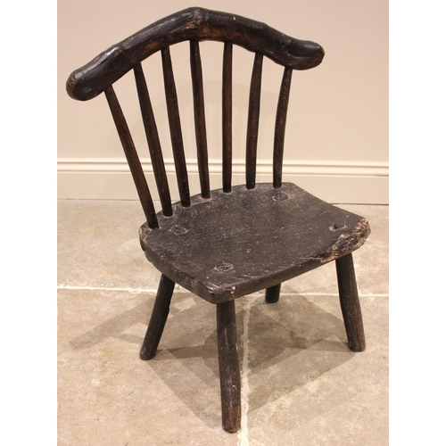 920 - A small Welsh primitive oak comb back chair, early 19th century, the rough cut crescent shaped top r... 