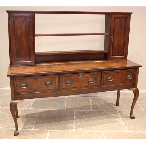 925 - A George III oak dresser, the reduced plate rack with two open shelves flanked by spice cupboards, u... 