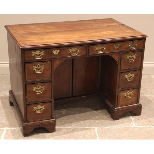 926 - A George III mahogany kneehole desk, the moulded crossbanded top above a pair of oak lined frieze dr... 