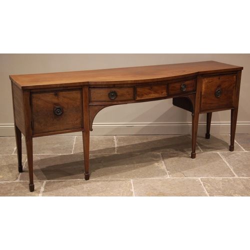 937 - A Regency mahogany sideboard, of break arch form, outlined with boxwood stringing, the central conve... 