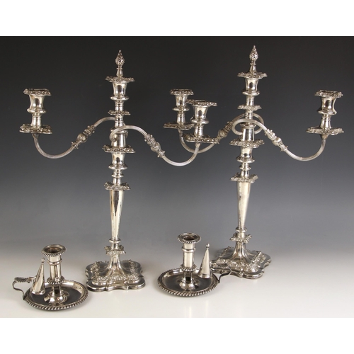 94 - A pair of large silver plate candelabra, the cast floral removeable drip pans above urn shaped sconc... 