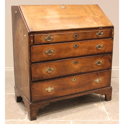 940 - A George III fruitwood bureau, the fall front opening to a compartmented interior with central ogee ... 