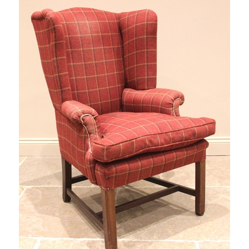 943 - A George III style wingback armchair, later re-covered in red tartan fabric, the shaped wingbacks ex... 