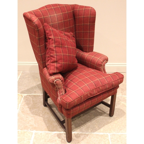 943 - A George III style wingback armchair, later re-covered in red tartan fabric, the shaped wingbacks ex... 