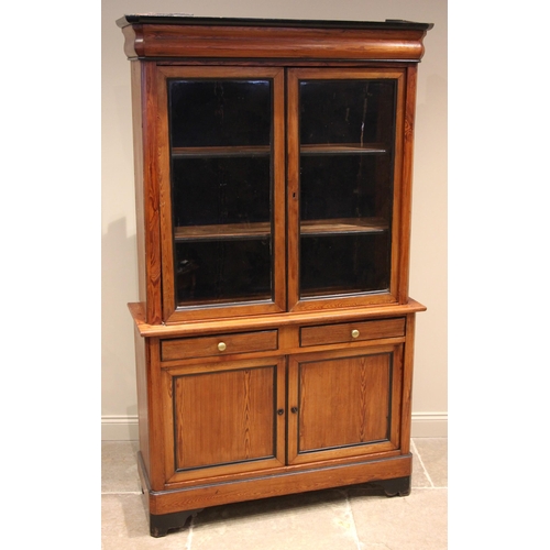 977 - A pitch pine glazed bookcase, late 19th century, the ogee moulded cornice embellished with ebonised ... 