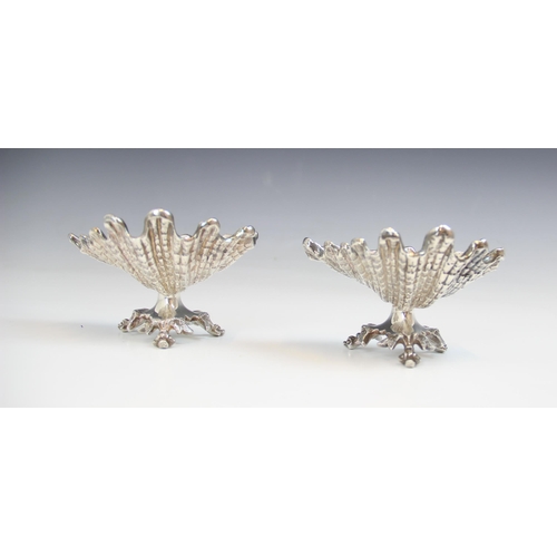 98 - A pair of silver plate salts, 20th century, each modelled as a scalloped shell, upon stylised bird f... 