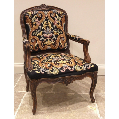 984 - A Louis XV style stained beech and tapestry upholstered fauteuil, mid 20th century, the frame carved... 