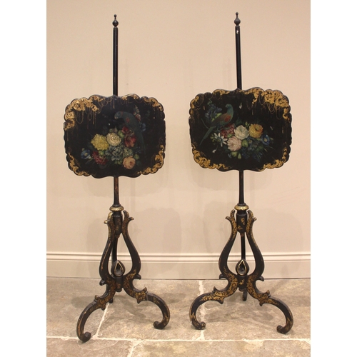 994 - A pair of Victorian papier mache ebonised pole screens, each with a scalloped panel painted with a p... 