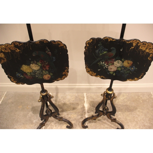 994 - A pair of Victorian papier mache ebonised pole screens, each with a scalloped panel painted with a p... 