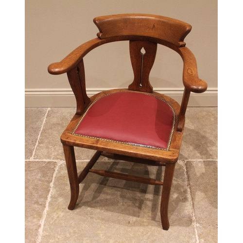 1046 - An Arts & Crafts oak desk chair, early 20th century, the horse shoe shaped top rail upon three splat... 