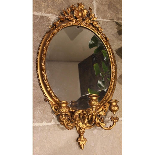 878 - A 19th century giltwood and gesso girandole wall mirror, with an openwork foliate crest over the ova... 