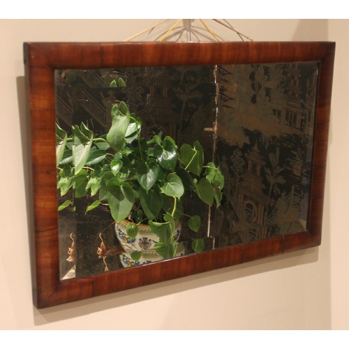 880 - A Victorian mahogany framed wall mirror, of rectangular cushion form, enclosing a bevelled mirrored ... 