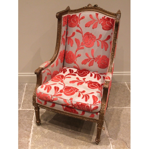 931 - A French Louis XVI style wing back armchair, 19th century, re-covered in embossed red foliate fabric... 