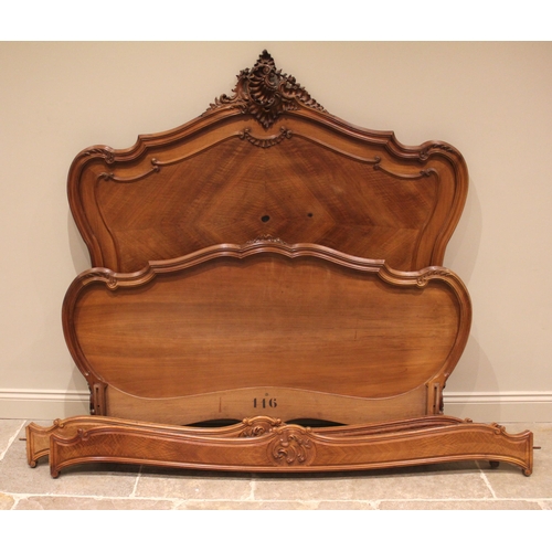 988 - A French walnut bed, late 19th/early 20th century, the shaped headboard with a carved shell and foli... 