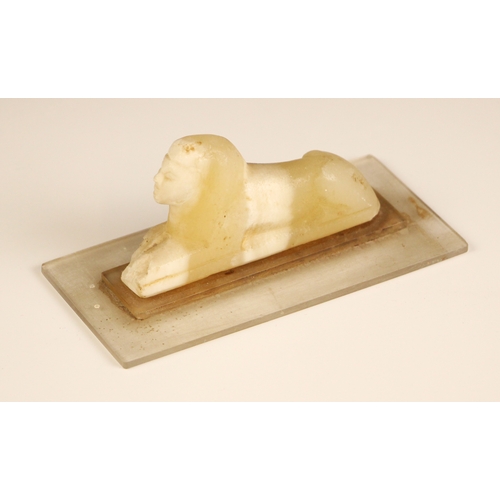 313 - An Egyptian Grand Tour carved alabaster Sphinx, modelled upon a perspex base, carving 9.5cm long