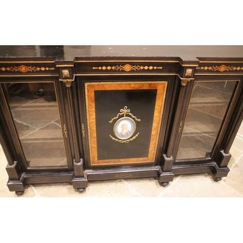 1014 - A Victorian ebonised and walnut banded credenza, the central cupboard door inset with an oval French... 