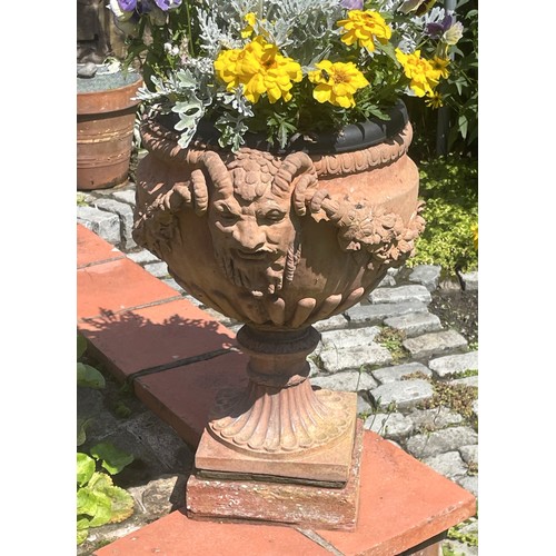 862 - A pair of terracotta garden urns, moulded in relief, with horned masks and swags, 49cm H x 33cm D (2... 