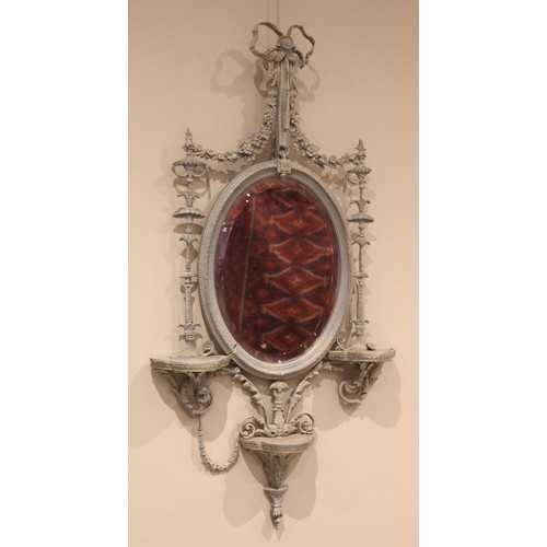 874 - A 19th century painted gesso Adam style wall mirror, the oval mirror plate within an elaborate openw... 