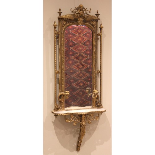 875 - A Victorian giltwood and gesso wall mirror and shelf, the arched frame decorated with fern leaves an... 