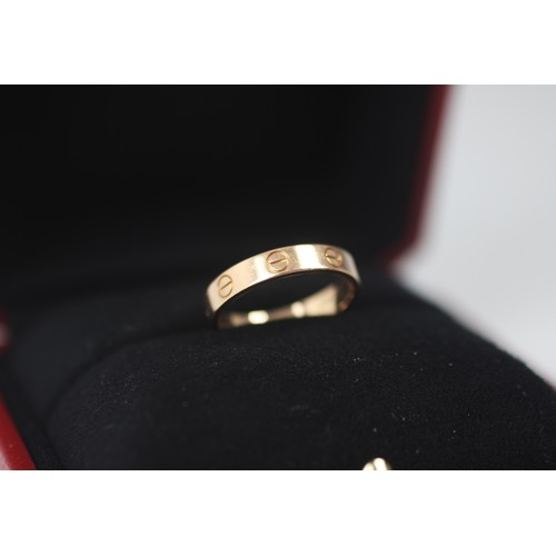 299 - A rose gold 'Love' ring, by Cartier, the polished band ring with six screw head motifs, stamped to i... 