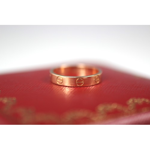 299 - A rose gold 'Love' ring, by Cartier, the polished band ring with six screw head motifs, stamped to i... 