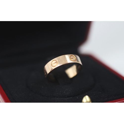 298 - A rose gold 'Love' ring, by Cartier, the polished band ring with six screw head motifs, stamped to i... 