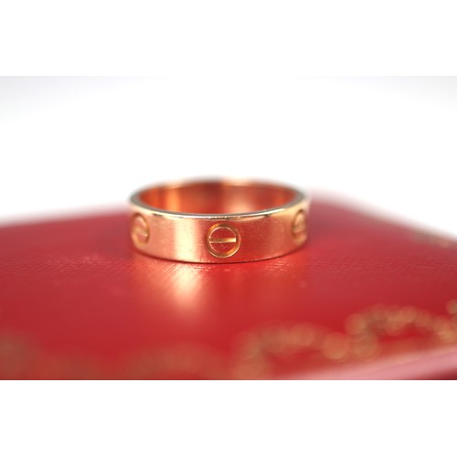 298 - A rose gold 'Love' ring, by Cartier, the polished band ring with six screw head motifs, stamped to i... 