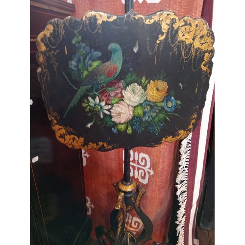 994 - A pair of Victorian papier mache ebonised pole screens, each with a scalloped panel painted with a p... 