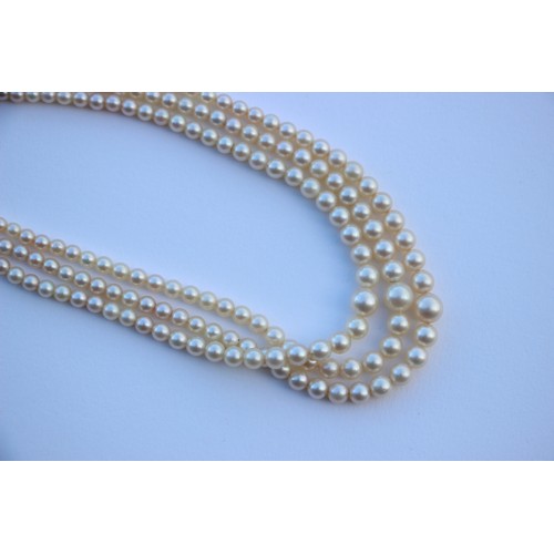 283 - A triple strand of pearls, the graduated pearls of non uniform form, upon an associated marcasite se... 